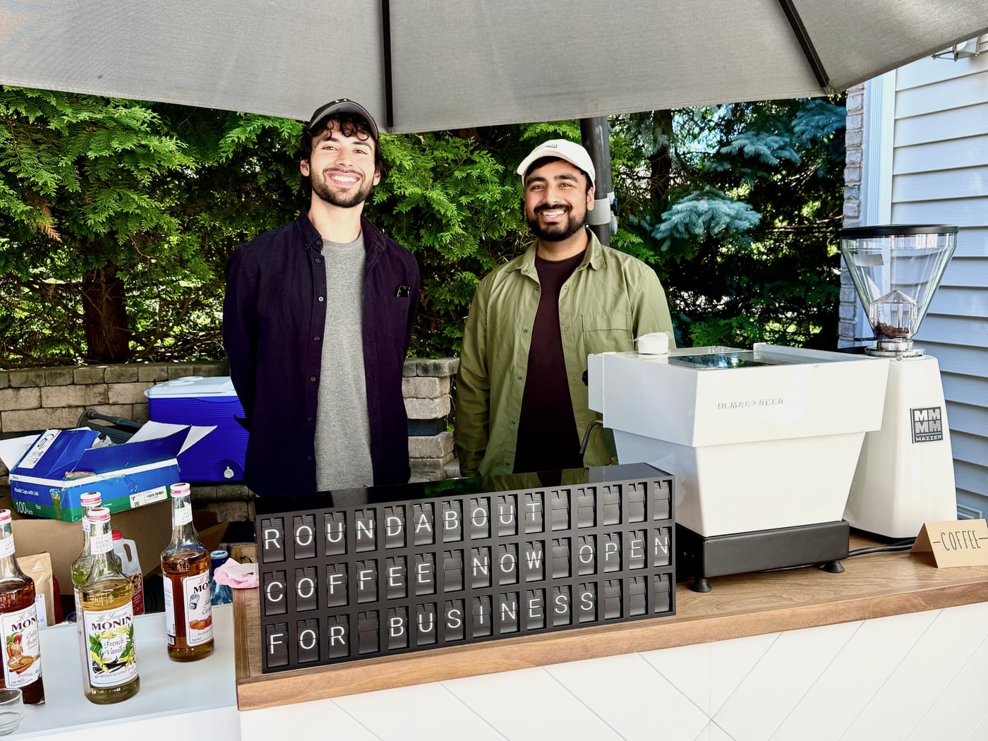 Roundabout Coffee cart with staff and branded Vestaboard