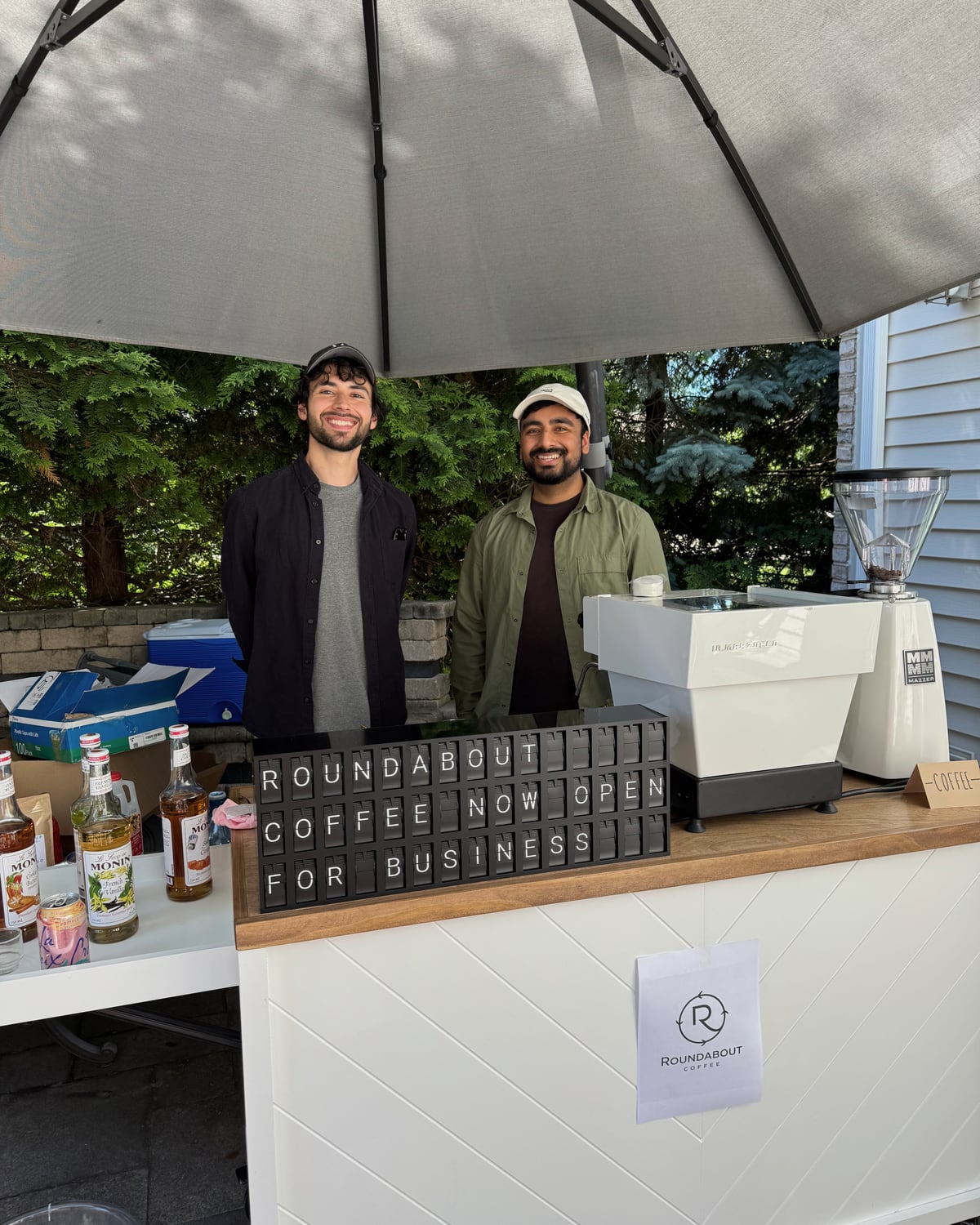 Roundabout Coffee team standing behind the mobile coffee cart